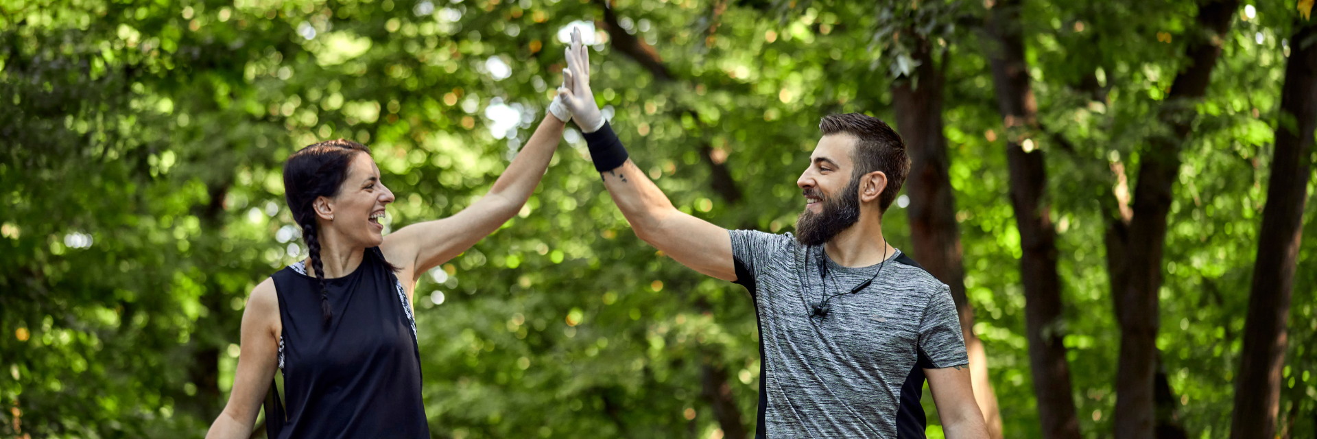 Casal feliz caminhando pela floresta.